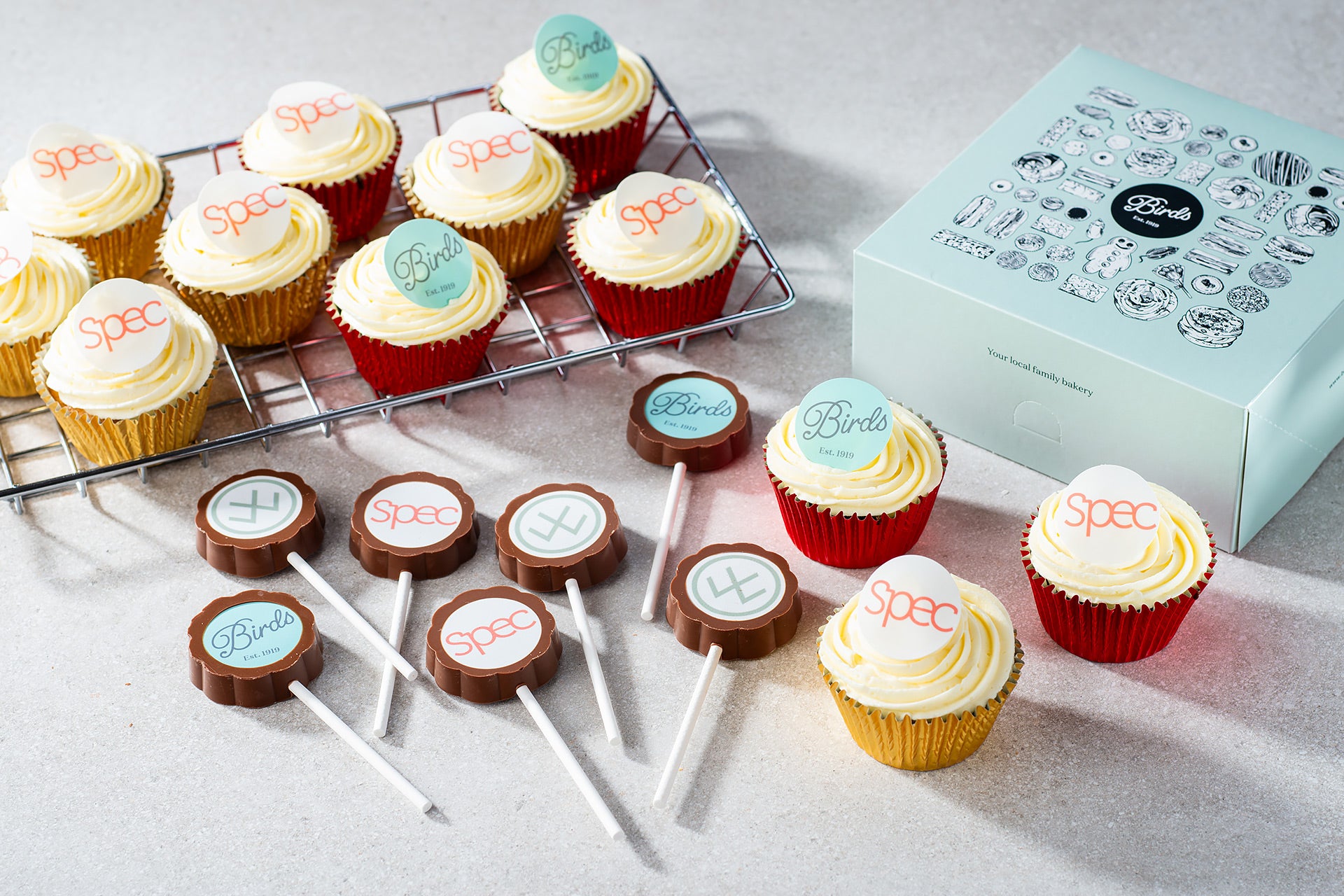 A selection of chocolate lollypops and cupcakes with brand logos
