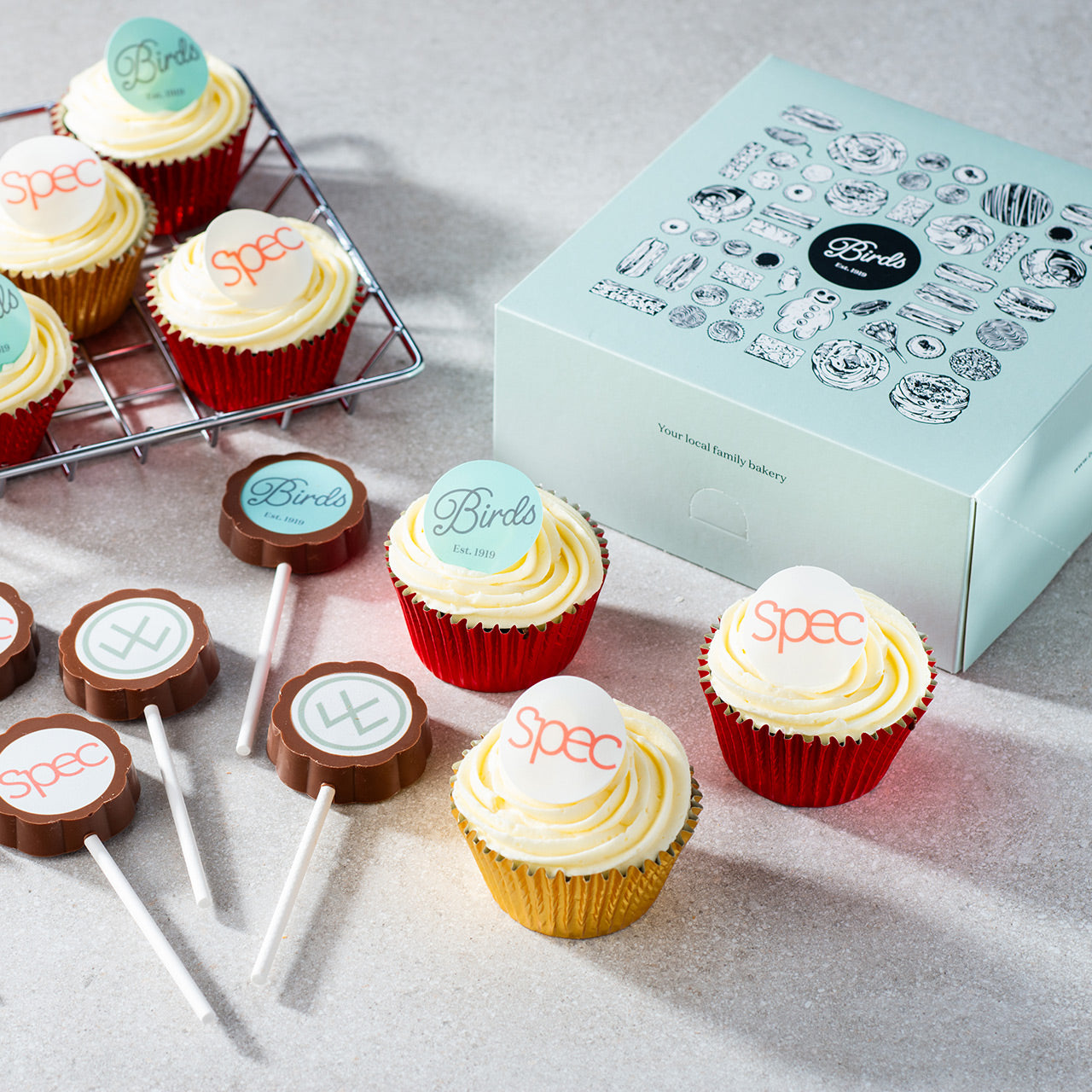 A selection of chocolate lollypops and cupcakes with brand logos